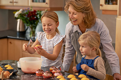 Buy stock photo Mature woman, children and smile for baking in retirement for family, fun and bonding at home. Happy, female pensioner and girl with cupcake, laugh and icing for creative fun together in kitchen
