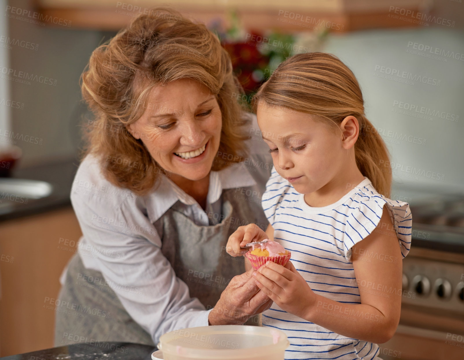Buy stock photo Elderly woman, child and smile for baking, teaching and bonding together at weekend in family home. Happiness, grandmother and kid with hand, cupcake and icing for playful learning in kitchen