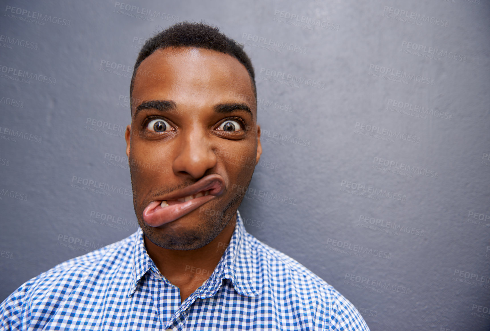 Buy stock photo Goofy, funny and portrait of black man by wall for comic, playful or comedy joke expression. Silly, crazy and face of confident young African male person by gray background with mockup space.