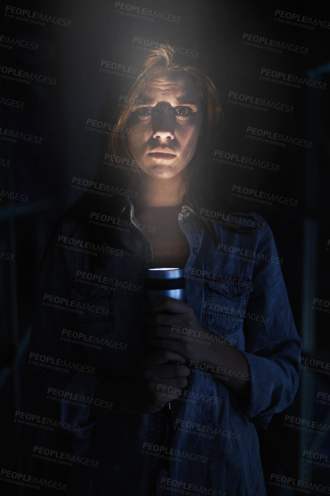 Buy stock photo Portrait, horror and torch for light with woman on black background to hide from fear, panic or terror. Stress, depression and mental health with scared young person in dark for danger or violence