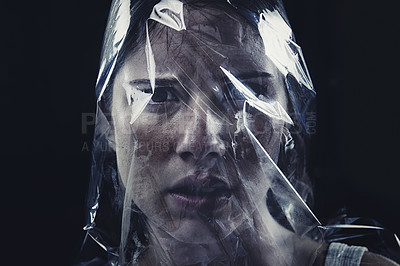 Buy stock photo Plastic, woman and bag on face with scary drama in studio, dark background or afraid of death. Suffocation, murder and girl with fear from crime, victim and trapped in trash, garbage or pollution