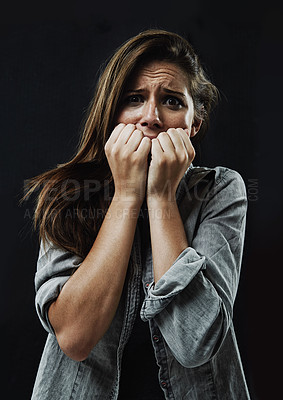 Buy stock photo Portrait, horror and woman biting nails in studio on black background for reaction to fear or terror. Face, anxiety and mental health with scared young person in dark for stress, phobia or nightmare