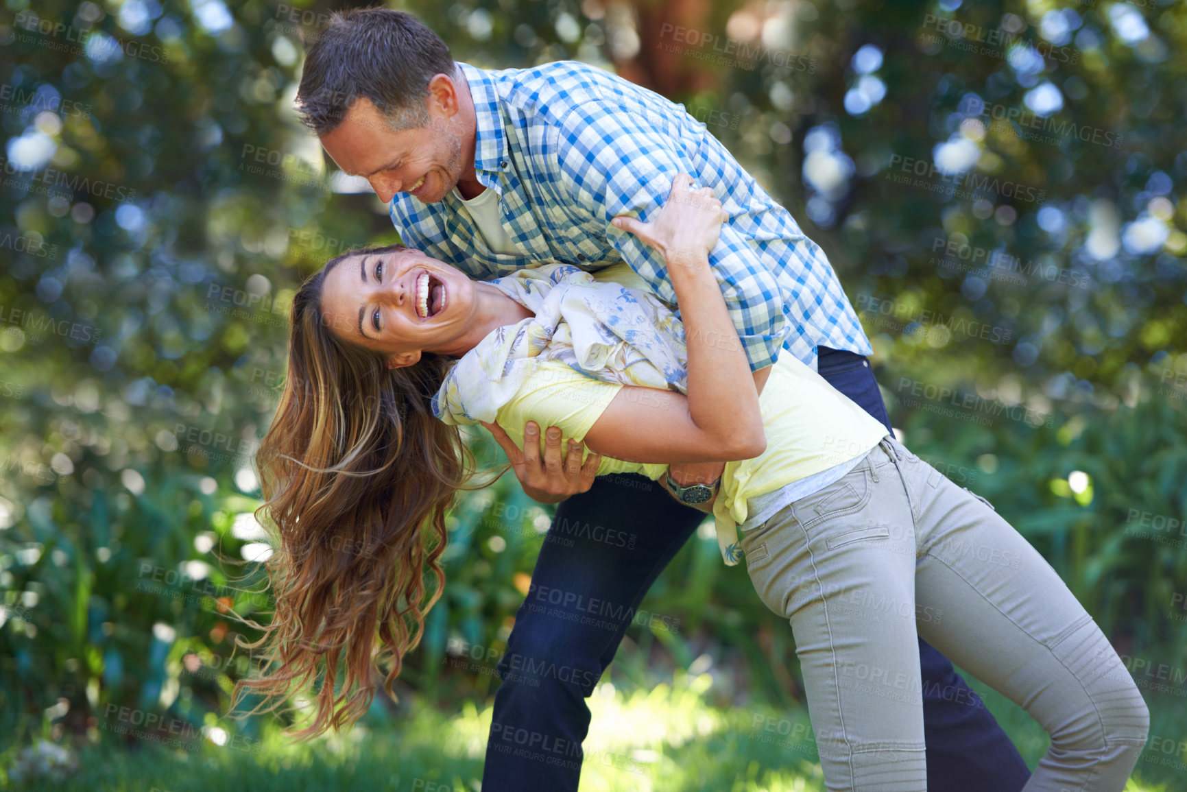 Buy stock photo Love, smile and playful couple in park for summer fun and outdoor date together in nature. Romance, mature man and happy woman in garden with morning sunshine, playing and marriage bonding in trees.