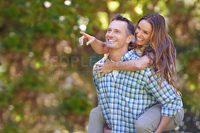 Buy stock photo A handsome man giving his wife a piggyback outdoors