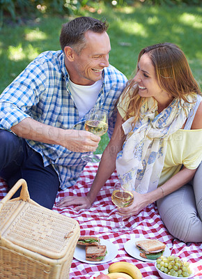 Buy stock photo Couple, picnic and alcohol for bonding in outdoor nature, love and romance in relationship on weekend. Wine glasses, conversation and people on date in countryside, adventure and forest for happy