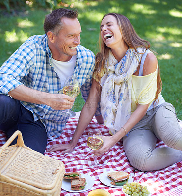 Buy stock photo Love, laughing and picnic with couple in park together, drinking wine for celebration, romance or bonding. Food, smile or funny with happy mature man and woman on grass for anniversary in summer