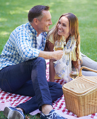 Buy stock photo Couple, picnic and wine on travel in outdoor nature, love and romance in relationship on weekend. Alcohol, conversation and people on date in countryside, adventure and grass to relax on vacation