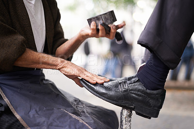 Buy stock photo Cropped shot of a shoe shiner shining a businessman's shoes