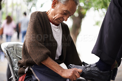 Buy stock photo Cropped shot of a shoe shiner shining a businessman's shoes