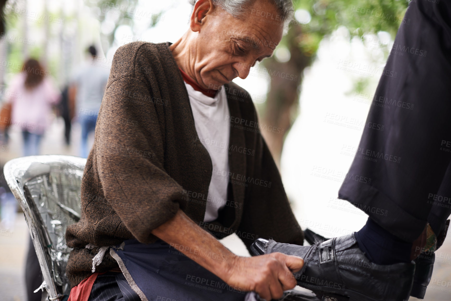 Buy stock photo Cropped shot of a shoe shiner shining a businessman's shoes