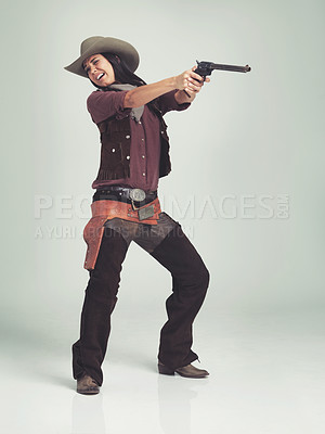 Buy stock photo Western, woman and cowboy with gun in studio for fashion, nervous and scared to shoot on grey background. Female person, vintage and outlaw with pistol for wild west, costume and character with hat