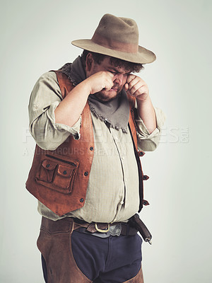 Buy stock photo Cowboy person, crying and sad in studio, bandit and plus size man on white background. Dress up, fake and Halloween outfit or character, Texas criminals and vintage for retro theme in costume
