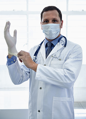 Buy stock photo Portrait, doctor and putting on gloves in mask for protection or safety in hospital. Face, medical professional and man with ppe to prepare for surgery, treatment or prevention of disease for health