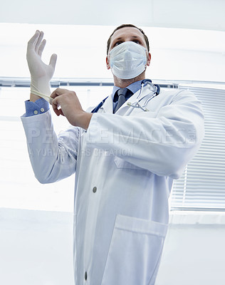 Buy stock photo Safety, doctor and man put on gloves in mask for protection or covid in hospital. Rubber, medical professional and ppe to prepare for surgery, treatment or prevention of disease in healthcare clinic