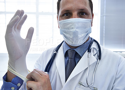 Buy stock photo Portrait, doctor and man put on gloves in mask for protection or safety in hospital. Face, medical professional and ppe to prepare for surgery, treatment or prevention of disease in healthcare clinic