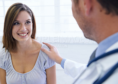 Buy stock photo A young woman being reassured by her doctor during a consultation