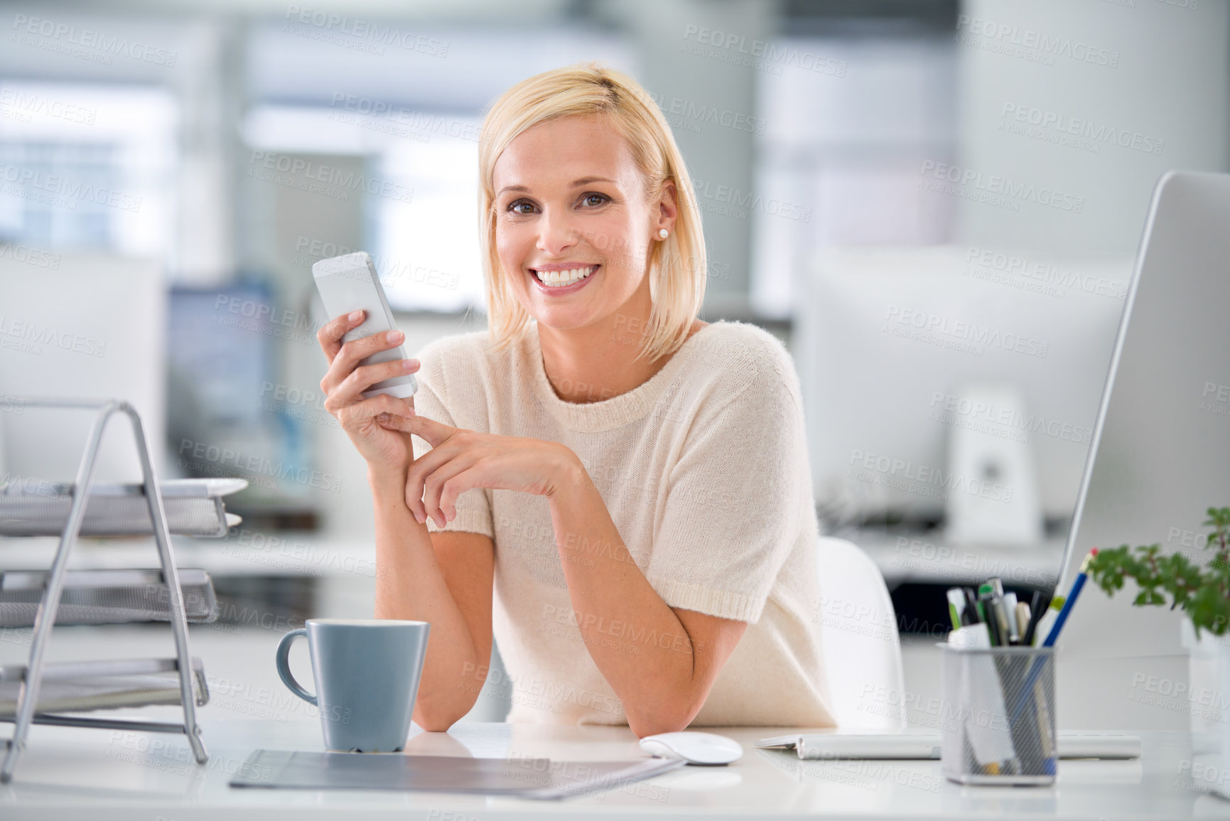 Buy stock photo Cropped shot of a businesswoman using her cellphone at her desk