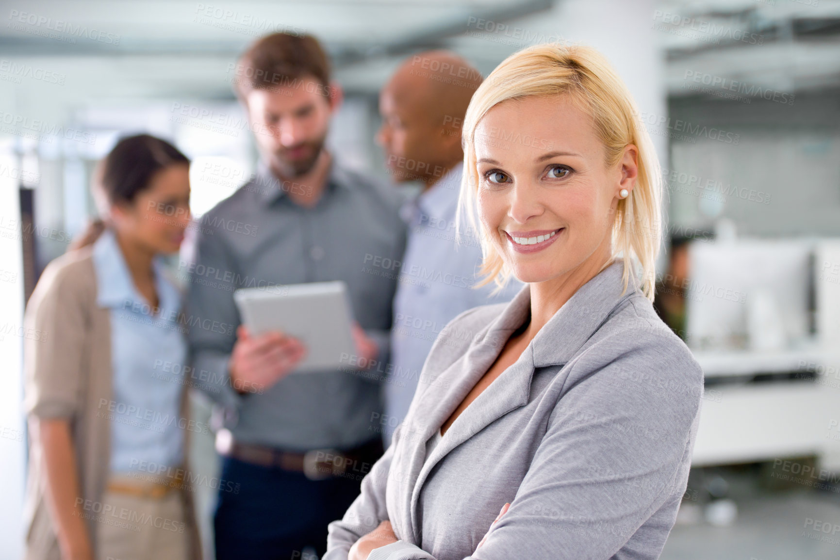Buy stock photo Cropped shot of a young businesswoman with her colleagues working in the background