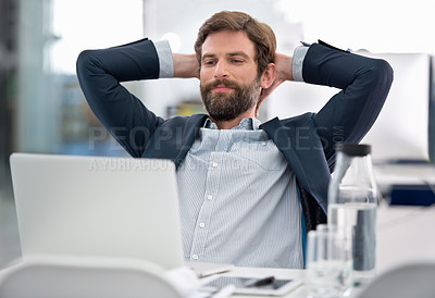 Buy stock photo Shot of a young businessman sitting at his workstation in an office