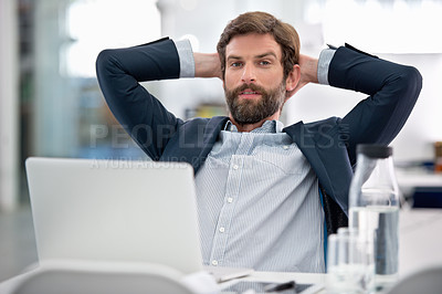 Buy stock photo Shot of a young businessman sitting at his workstation in an office