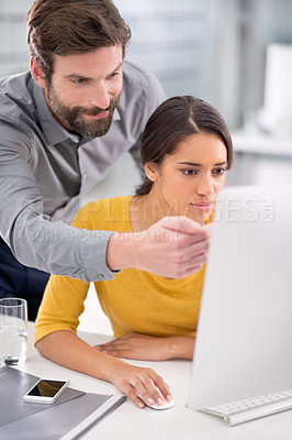 Buy stock photo Two colleagues working together in front of a computer