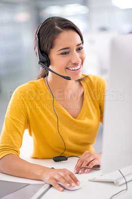 Buy stock photo Shot of a young customer service representative wearing a headset while sitting by her computer