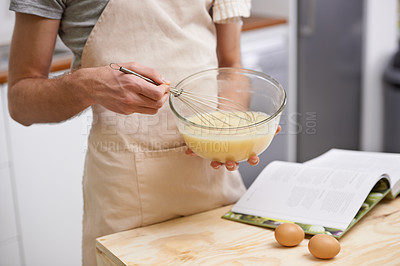 Buy stock photo Cropped shot of a young man cooking in the kitchen