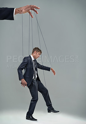 Buy stock photo A businessman being controlled like a puppet