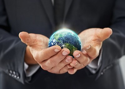 Buy stock photo Cropped image of a businessman holding a globe in his cupped hands
