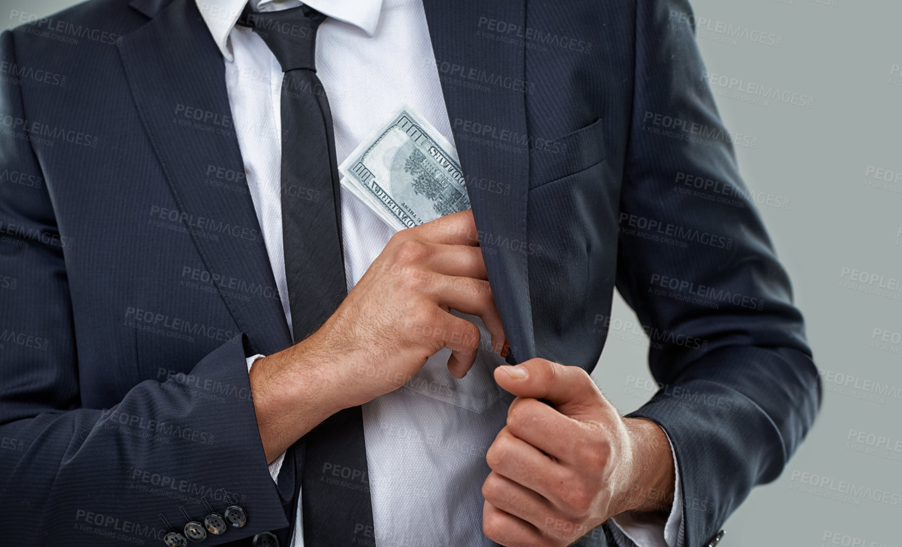 Buy stock photo Cropped image of a businessman putting money in his pocket