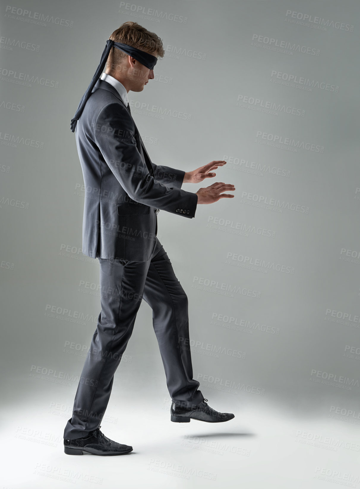 Buy stock photo A blindfolded businessman trying to walk across the room