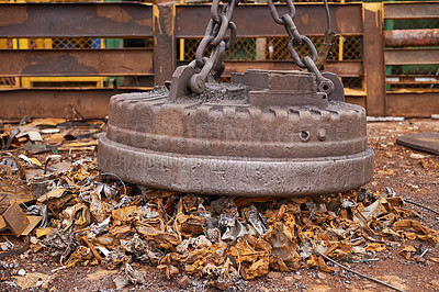 Buy stock photo A large magnet picking up trash in a trashyard