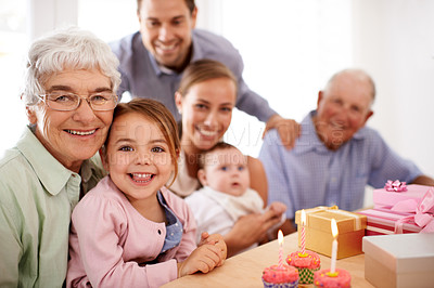 Buy stock photo Grandparents sitting with their granddaughter on her birthday