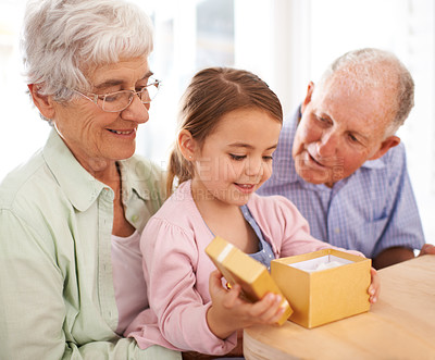Buy stock photo Grandparents, child and opening gift box for birthday or special event, old people and young girl for celebration. Gratitude, thanks for surprise and unboxing present with family bond and happiness