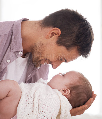 Buy stock photo Side view of a young father holding and looking at his adorable baby girl
