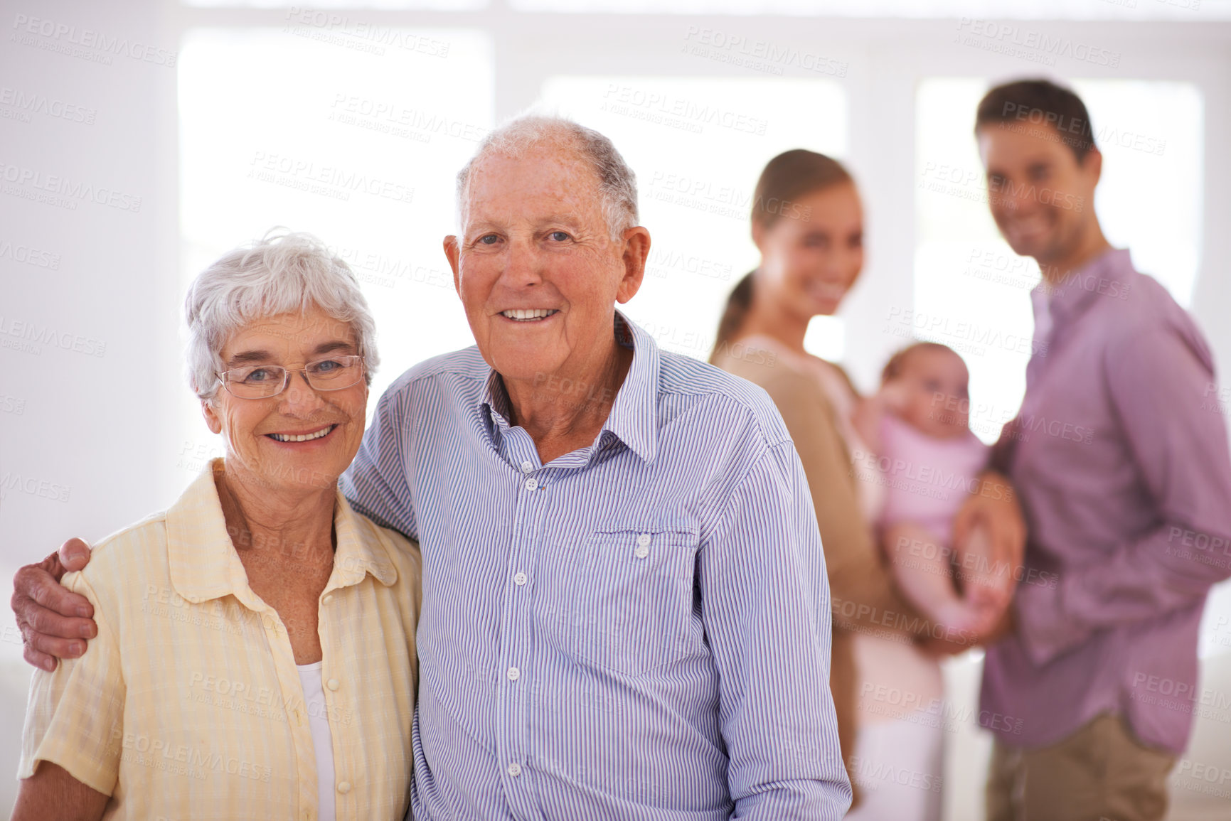 Buy stock photo Senior, couple and happy portrait in home with hug, family and commitment to marriage in living room. Elderly, man and woman with face, smile and embrace in lounge of house for romance, love or care 