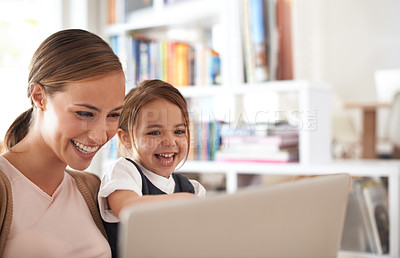 Buy stock photo Shot of a mother using a laptop with her daughter
