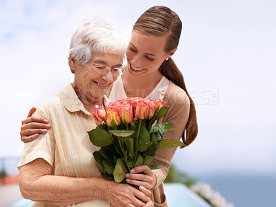 Buy stock photo Cropped shot of a young woman giving her mother a bunch of roses