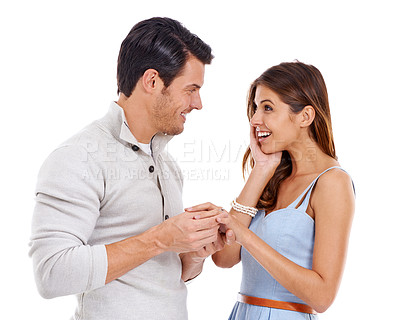 Buy stock photo Happy, couple and ring with engagement news, announcement and yes to commitment and marriage. Proposal, surprise and smile in studio with love, jewelry and romance with white background and question