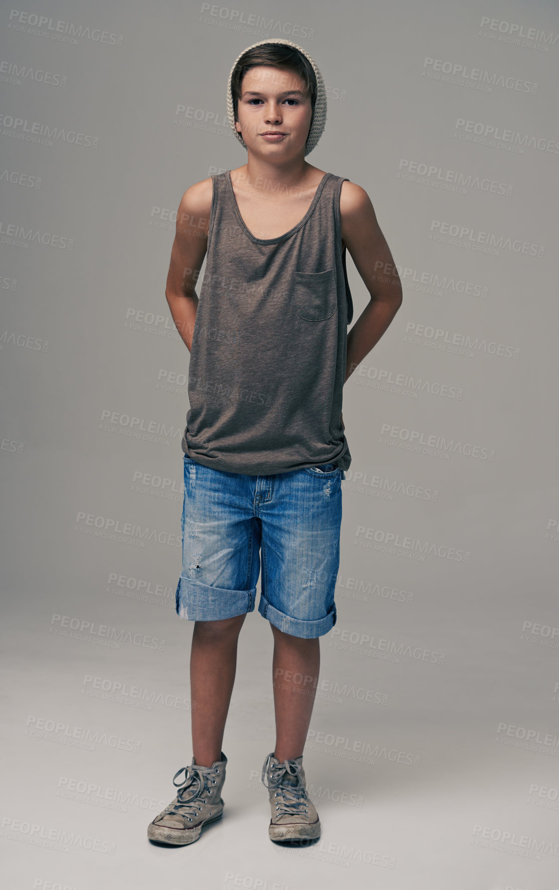 Buy stock photo Young boy, portrait and fashion with denim shorts or jeans for style on a gray studio background. Male person, child or teenager with summer clothing or cool stylish outfit with beanie on mockup