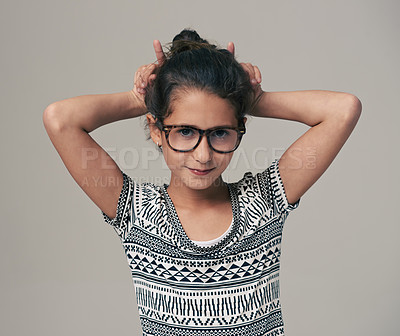 Buy stock photo Portrait, funny face and glasses with girl child in studio isolated on gray background for optometry style. Kids, hand gesture or eyewear with cute young geek or nerd in outfit and accessories