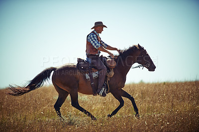 Buy stock photo Shot of a man riding a horse in a field