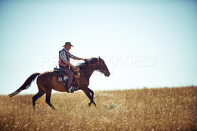 Buy stock photo Cowboy, adventure and man riding horse with saddle on field in countryside for equestrian or training. Nature, summer or rodeo and mature horseback rider on animal running outdoor in rural Texas