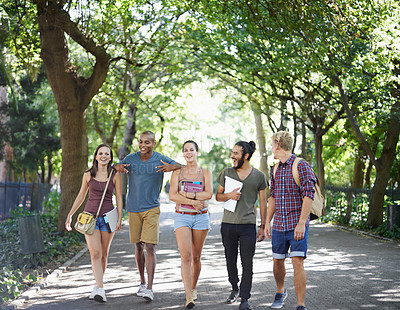 Buy stock photo Students, friends and walking on campus with learning, knowledge and books or talking of college. Group of people with outdoor conversation in a park or university for education, study or opportunity