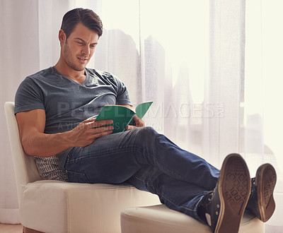 Buy stock photo Man, relax or reading with book on chair in living room for story, literature or novel at home. Handsome male person or young adult for information, knowledge or learning in leisure or break at house