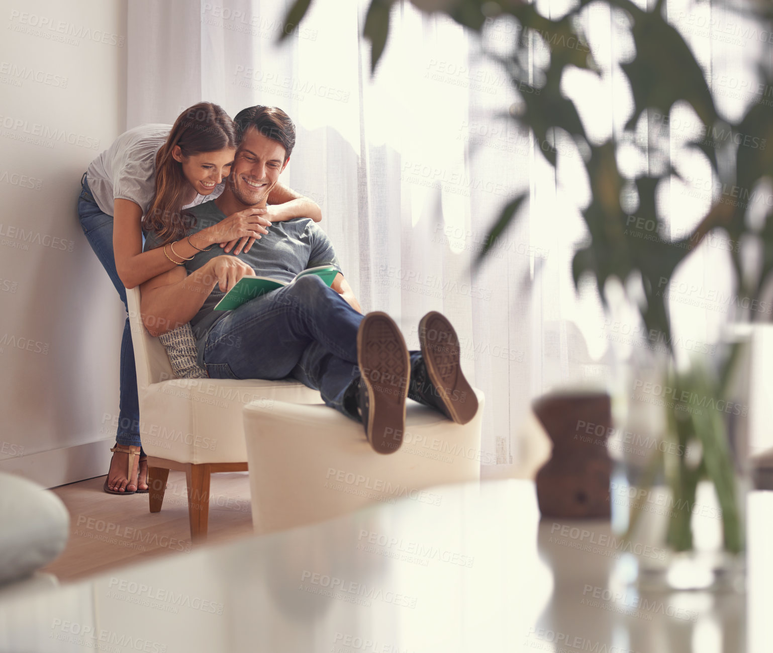 Buy stock photo Shot of an affectionate young couple relaxing at home