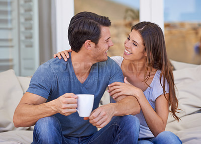 Buy stock photo Coffee, smile and couple on outdoor sofa for conversation, bonding or love on patio in morning. Happy, talking and young man and woman laughing and drinking cappuccino, latte or espresso at home.