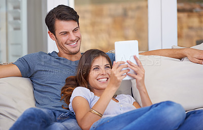 Buy stock photo Happy couple, relax and sofa with tablet for entertainment, movie or social media together at home. Man and woman laughing with smile on technology for online streaming, series or show in living room
