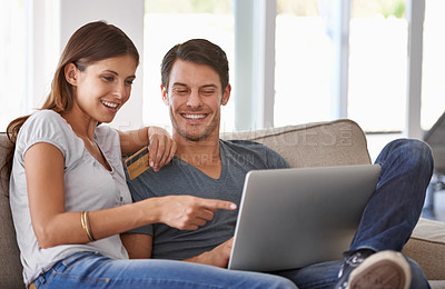 Buy stock photo An affectionate young couple doing some online shopping at home