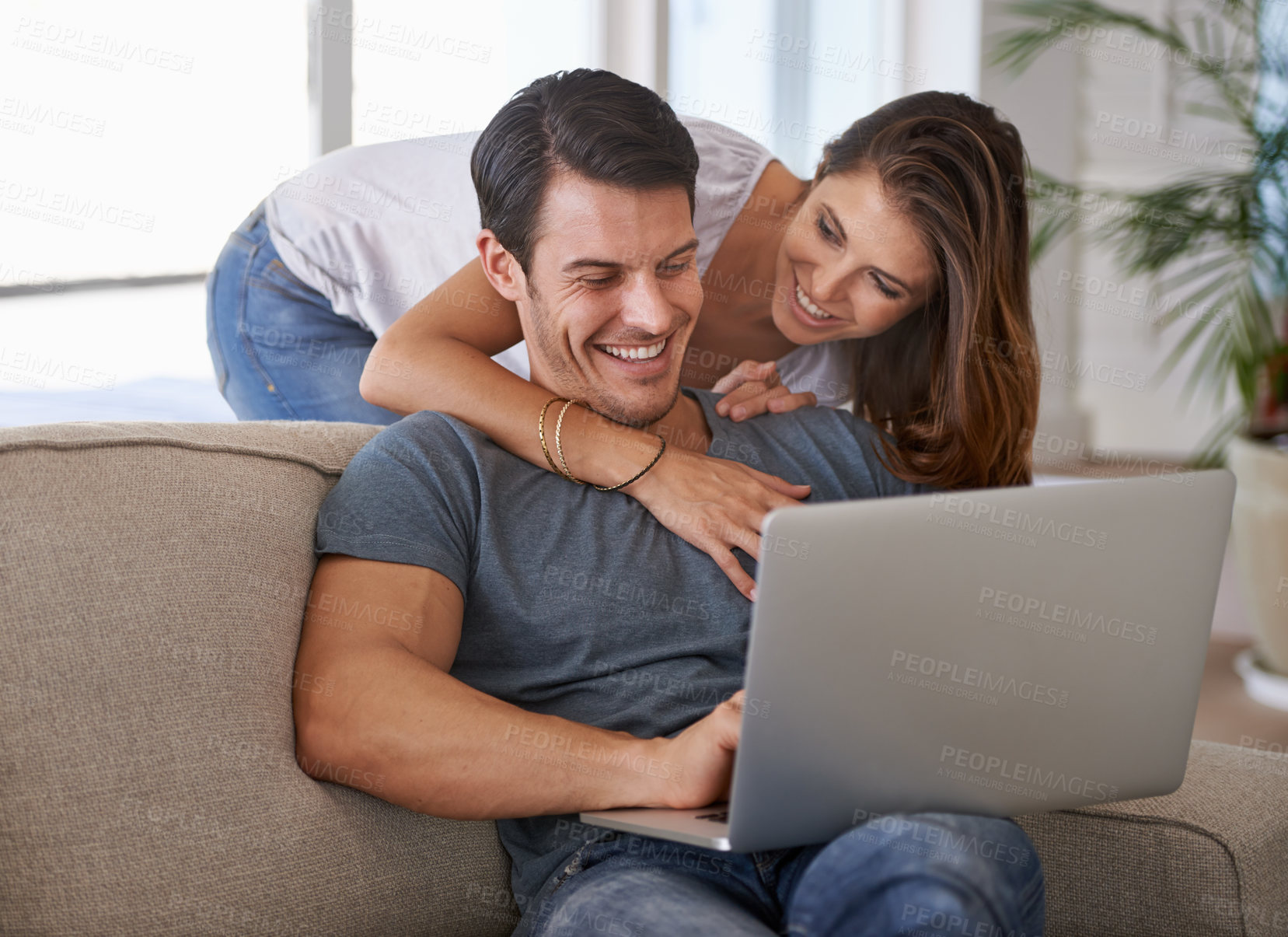 Buy stock photo Laptop, happy and woman hugging man on sofa networking on social media, website or internet. Smile, love and female person embracing husband reading online blog with computer in living room at home.